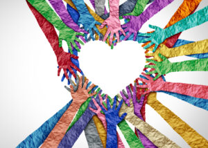 Hands cut out of many colors of paper come together to form a heart